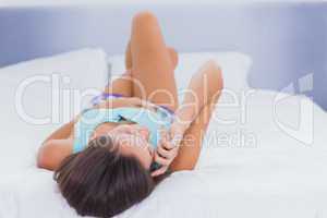 Woman on bed talking on phone