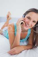 Woman lying in bed with phone