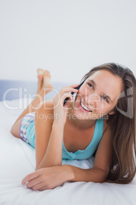 Casual woman using mobile phone in bed