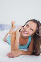 Casual woman using mobile phone in bed