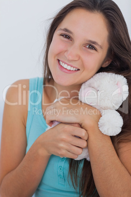 Young woman hugging a small teddy bear
