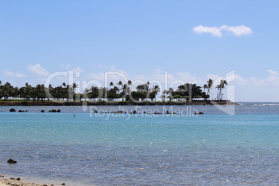 Meeresbucht mit klarem blauem Meer und Palmen im Hintergrund