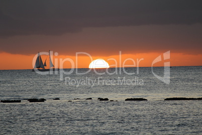 Roter Sonnenuntergang mit Segelyacht im Hintergrund
