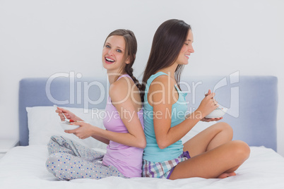 Friends in bed eating cereal