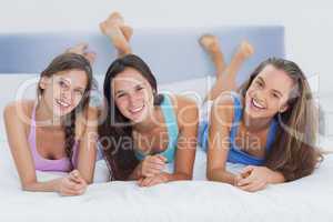 Friends lying on bed together