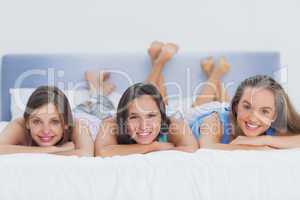 Three girls on bed looking at camera