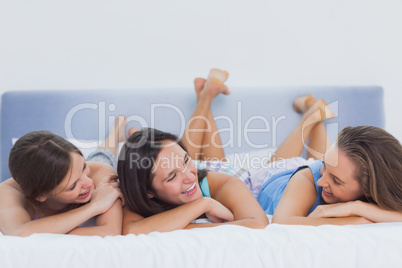 Friends lying on bed in pijamas