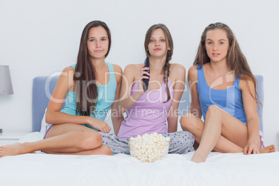 Girls sitting on bed at sleepover
