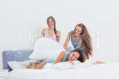 Happy girls having fun at slumber party in bed