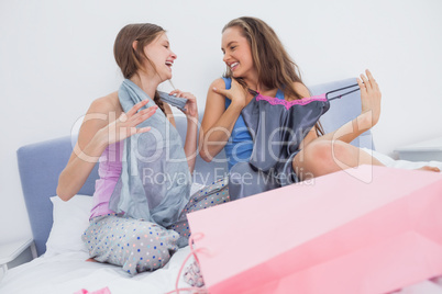 Teen girls sitting on bed after shopping