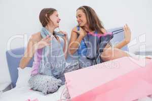 Teen girls sitting on bed after shopping