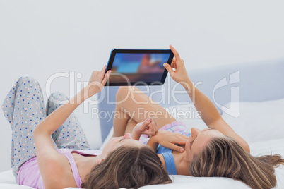 Friends wearing pajamas holding tablet