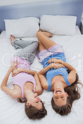 Girls wearing pajamas lying in bed