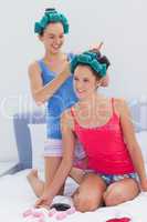 Girls in hair rollers and pajamas chatting