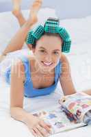 Girl in hair rollers lying in bed