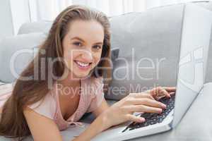 Casual young woman using laptop on sofa