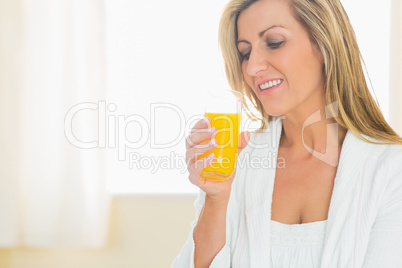 Smiling woman enjoying a glass of orange juice