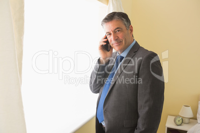 Pleased man calling someone with his mobile phone