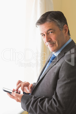 Amused man texting on his mobile phone