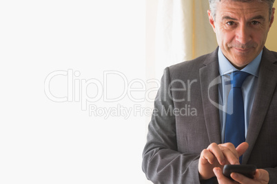 Amused man texting on his mobile phone