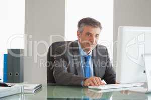 Smiling businessman using computer at office