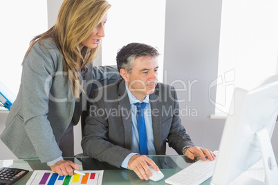 Two businesspeople looking at something on computer