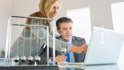 Businesswoman explaining something on the computer to a concentr