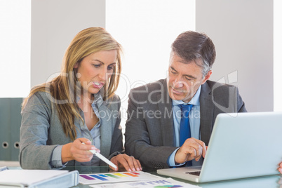 Serious businesswoman explaining figures to a concentrated busin
