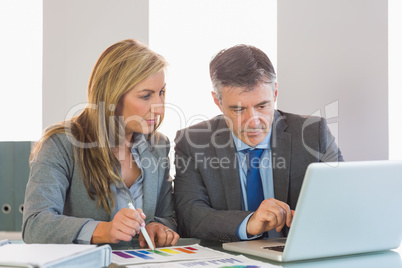 Attentive businessman showing something on computer to an attent