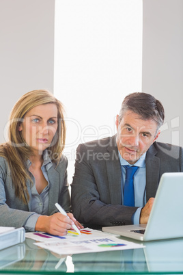 Two focused business people looking at camera trying to understa
