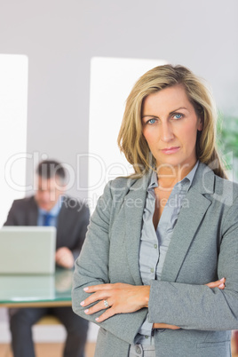 Serious businesswoman looking at camera crossed arms with a busi