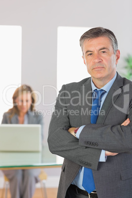 Irritated businessman looking at camera crossed arms with a busi