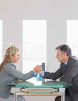 Two content businesspeople having an arm wrestling sitting aroun