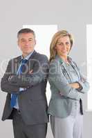 Two content businesspeople looking at camera standing back to ba