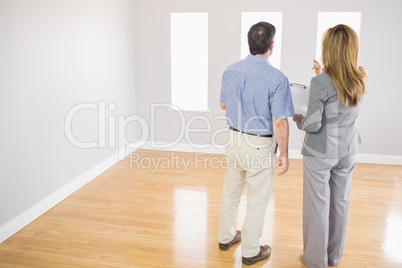 Blonde realtor showing a room to a potential buyer