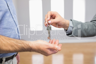 Estate agent giving house key to customer