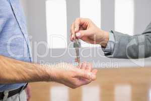 Estate agent giving house key to customer