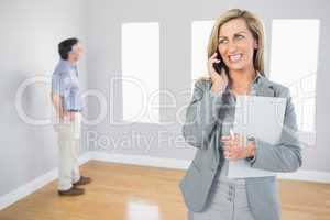 Cheerful realtor calling someone with her mobile phone