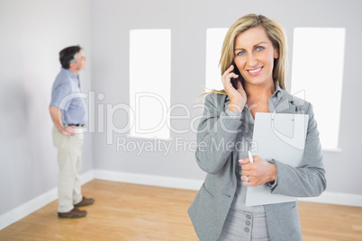 Happy realtor calling someone with her mobile phone