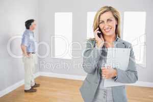 Happy realtor calling someone with her mobile phone