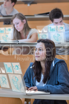 Serious pretty student working on her futuristic laptop