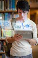 Serious handsome student working on his futuristic tablet pc