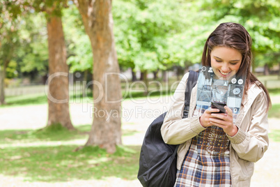 Smiling young woman texting on her futuristic smartphone