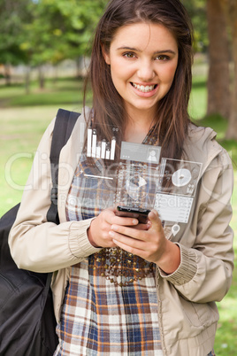 Happy young woman working on her futuristic smartphone