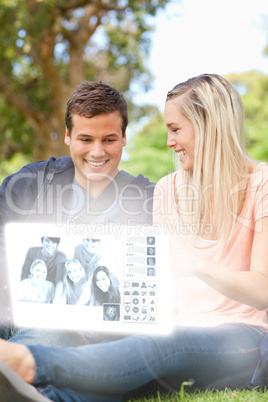 Smiling young couple watching photos on digital interface