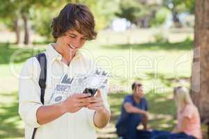 Happy student working on his digital smartphone