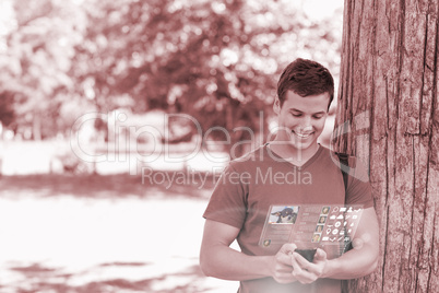 Smiling handsome student using his digital phone
