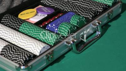 Hands close the aluminium suitcase with poker set.