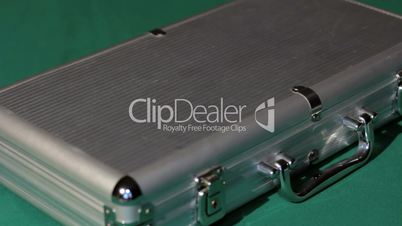 Hands open the aluminium suitcase with poker set.