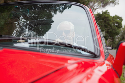 Handsome man driving red convertible